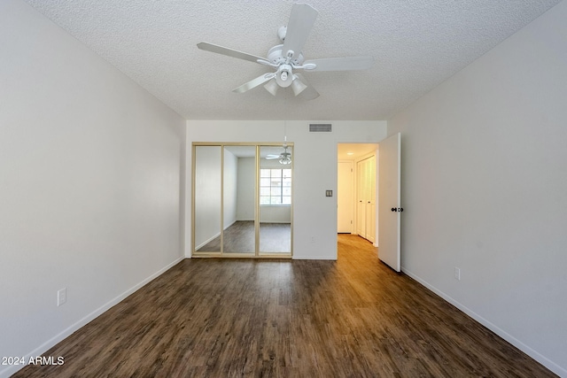 unfurnished bedroom featuring a textured ceiling, ceiling fan, a closet, and dark hardwood / wood-style floors