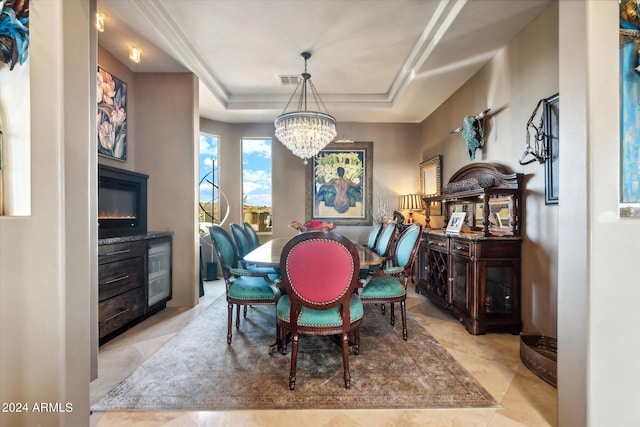 dining space featuring light tile patterned floors, a tray ceiling, and a notable chandelier