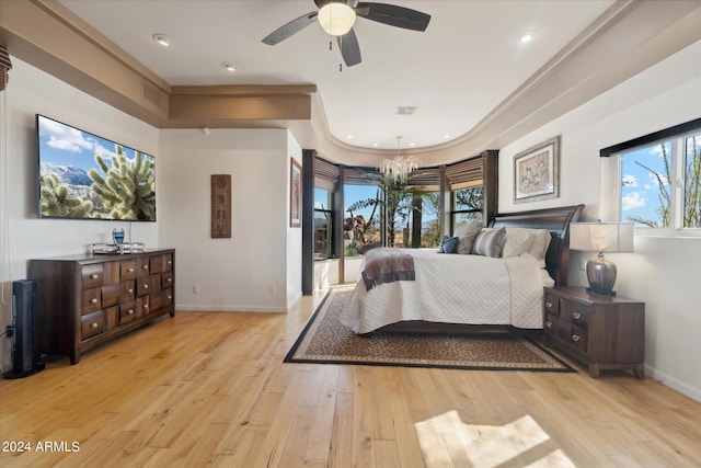 bedroom featuring ceiling fan with notable chandelier, light hardwood / wood-style flooring, and crown molding