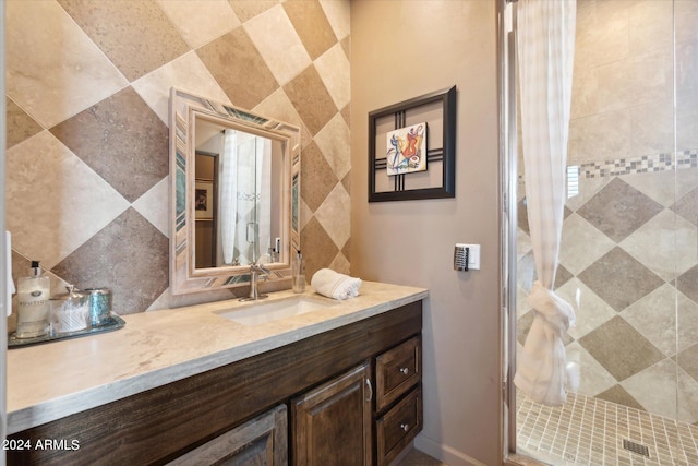 bathroom with vanity, a shower with shower door, and tile walls