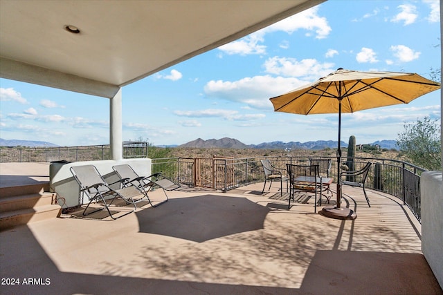 view of patio with a mountain view and a balcony