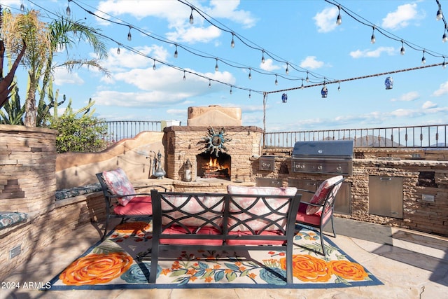 view of patio with an outdoor stone fireplace and area for grilling