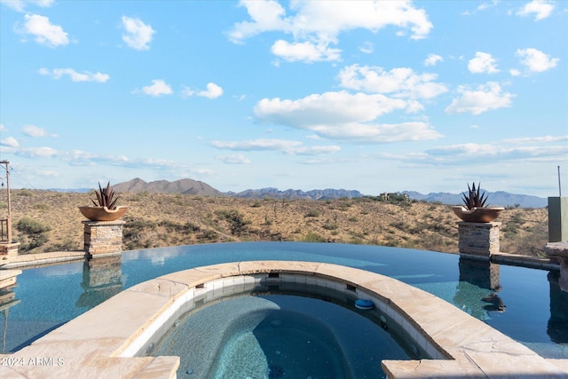 view of swimming pool featuring a mountain view and an in ground hot tub