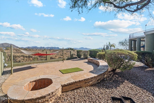 view of property's community with a mountain view and an outdoor fire pit