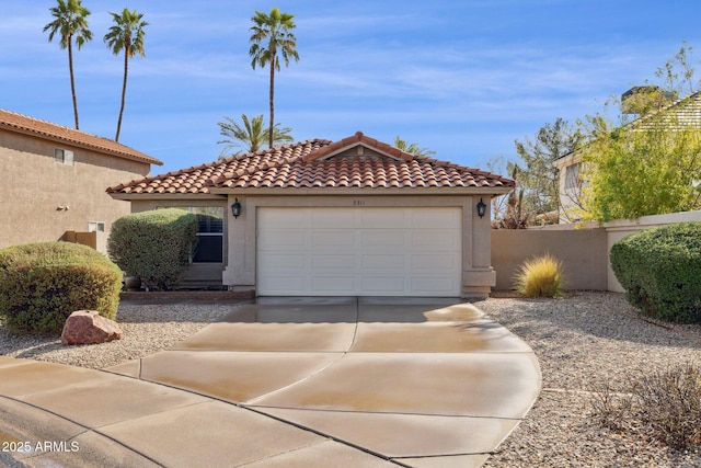 mediterranean / spanish-style house featuring a garage, driveway, a tiled roof, and stucco siding