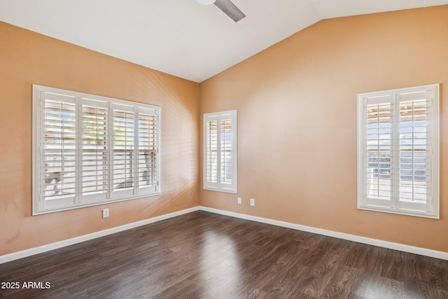 spare room with vaulted ceiling, dark wood-type flooring, and a healthy amount of sunlight