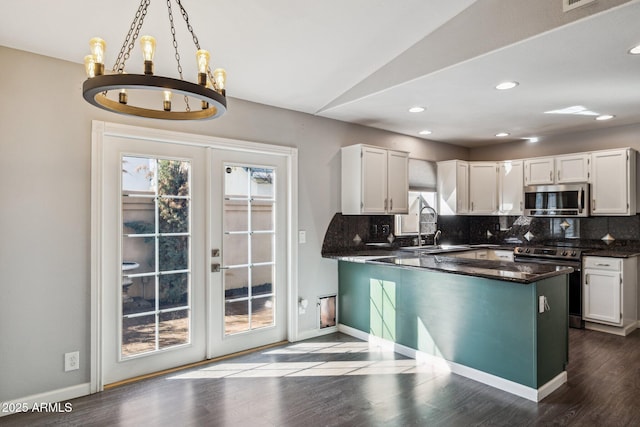 kitchen featuring tasteful backsplash, baseboards, white cabinets, dark wood finished floors, and appliances with stainless steel finishes