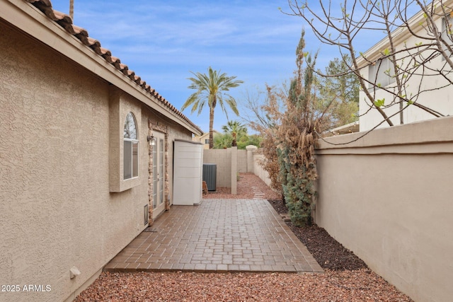 view of yard featuring a fenced backyard, a patio, and central air condition unit