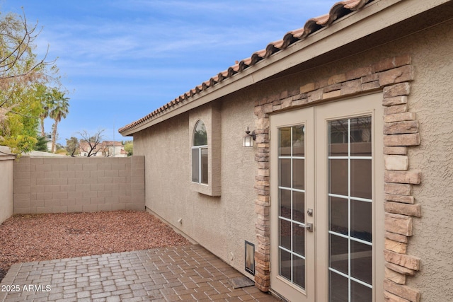 view of patio with french doors and fence