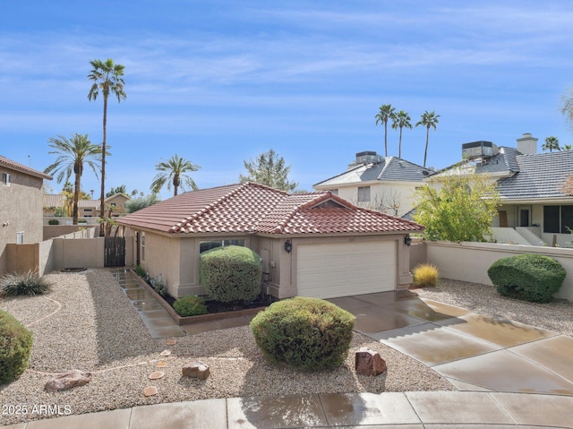 view of front of home featuring driveway, a tiled roof, an attached garage, fence, and stucco siding