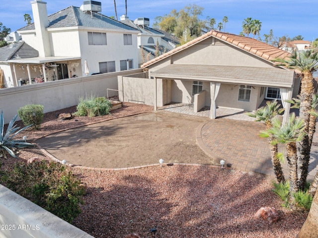 rear view of house featuring central AC unit, a patio area, fence, and stucco siding