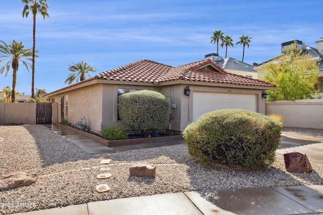 view of front facade with a garage, a tiled roof, fence, and stucco siding