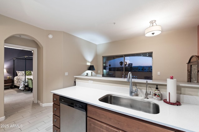 kitchen featuring stainless steel dishwasher, sink, and light hardwood / wood-style flooring