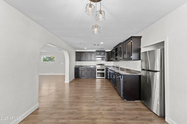 6714 N 26th Dr, Phoenix, AZ 85017 - kitchen featuring arched walkways, baseboards, a sink, and appliances with stainless steel finishes