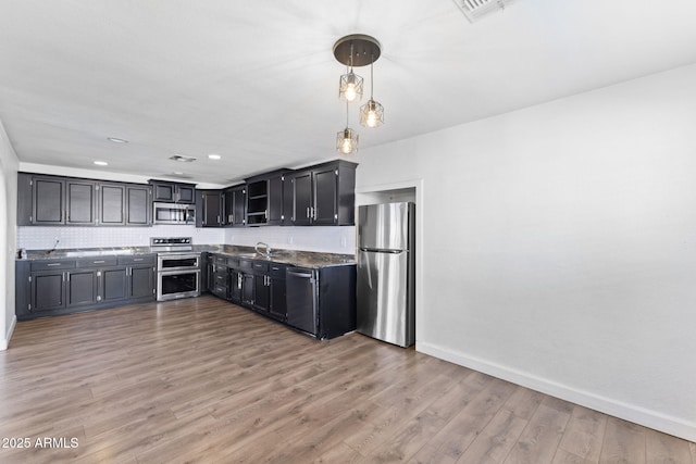 6714 N 26th Dr, Phoenix, AZ 85017 - kitchen with appliances with stainless steel finishes, baseboards, decorative backsplash, light wood finished floors, and a sink