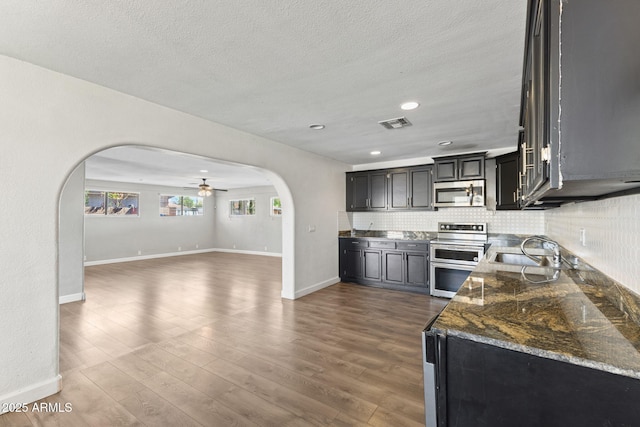 6714 N 26th Dr, Phoenix, AZ 85017 - kitchen with arched walkways, a ceiling fan, visible vents, a sink, and stainless steel appliances