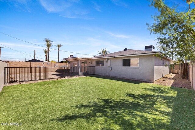 6714 N 26th Dr, Phoenix, AZ 85017 - back of house featuring a yard, a fenced backyard, and a chimney