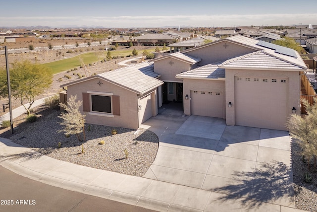 view of front facade with a tile roof, stucco siding, a garage, a residential view, and driveway