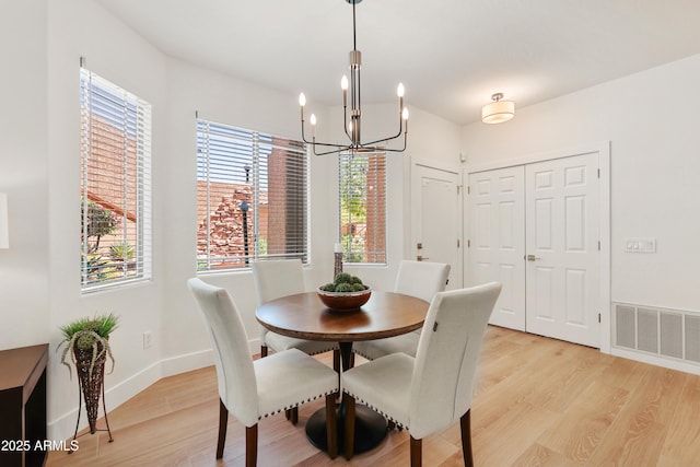 11500 E Cochise Dr Unit 1015, Scottsdale, AZ 85259 - dining area featuring visible vents, a healthy amount of sunlight, an inviting chandelier, and light wood-style floors