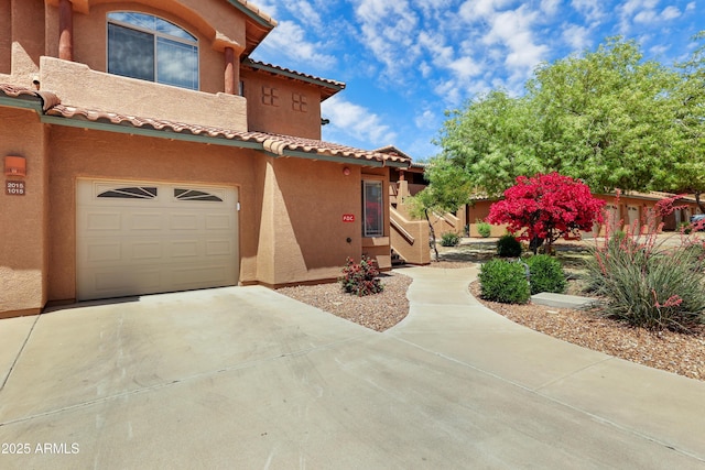 11500 E Cochise Dr Unit 1015, Scottsdale, AZ 85259 - view of home's exterior featuring an attached garage, driveway, a tile roof, and stucco siding