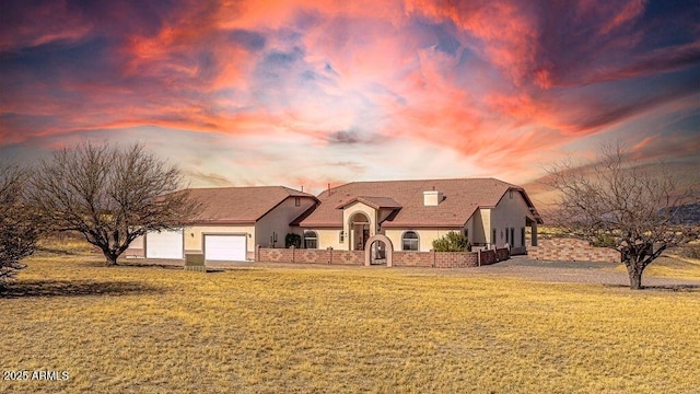 view of front of home featuring a front lawn, an attached garage, and stucco siding