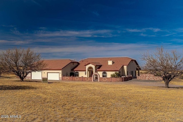 view of front of home featuring a garage, a front lawn, and stucco siding