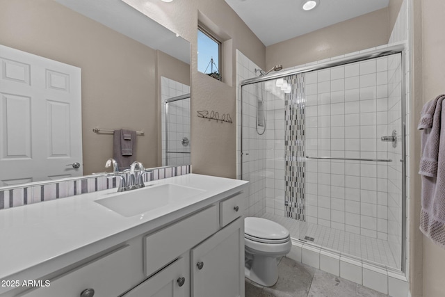 bathroom featuring tile patterned flooring, vanity, an enclosed shower, and toilet