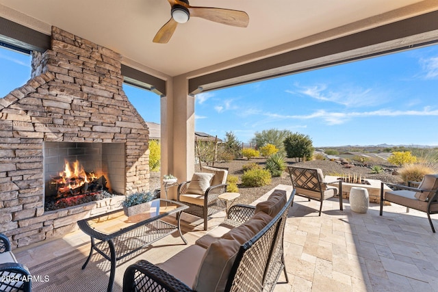 view of patio / terrace featuring an outdoor living space with a fireplace and ceiling fan