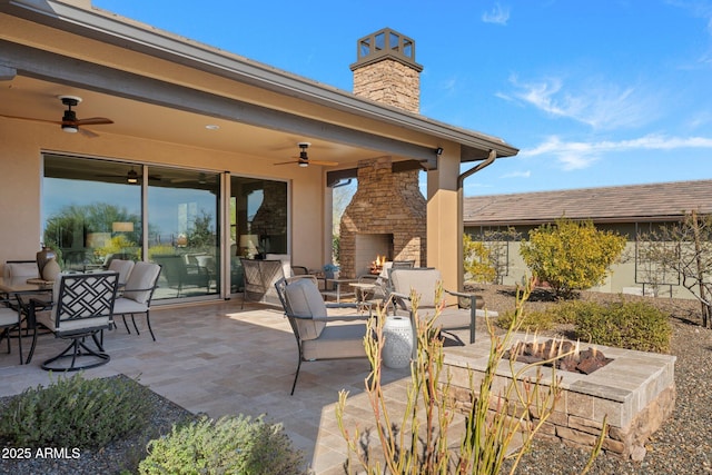 view of patio / terrace with ceiling fan and an outdoor stone fireplace