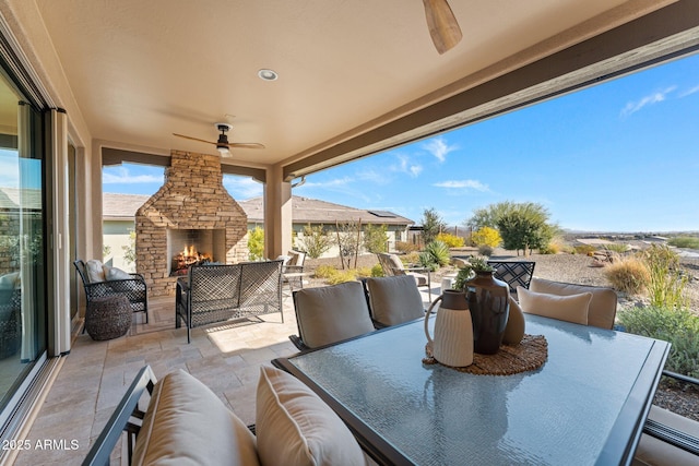 view of patio featuring an outdoor living space with a fireplace and ceiling fan