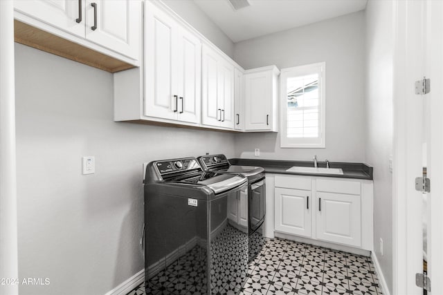 laundry room featuring washer and clothes dryer, cabinets, and sink