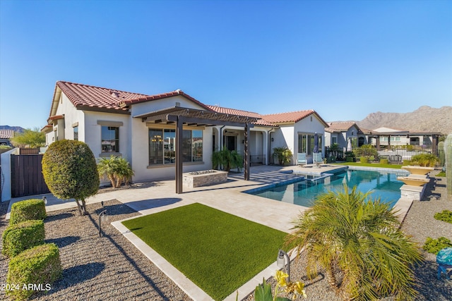 rear view of property with ceiling fan, a patio, and a fenced in pool