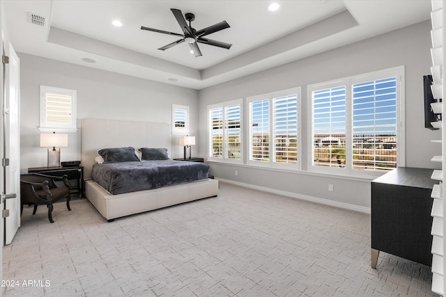 bedroom featuring ceiling fan and a raised ceiling