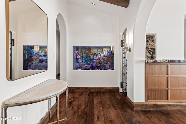 hallway with vaulted ceiling with beams and dark wood-type flooring