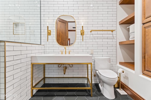 bathroom featuring tile patterned flooring, tile walls, and toilet