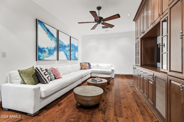 living room with ceiling fan and dark wood-type flooring