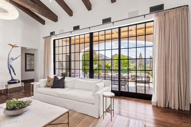 living room featuring beamed ceiling, a high ceiling, and dark hardwood / wood-style floors