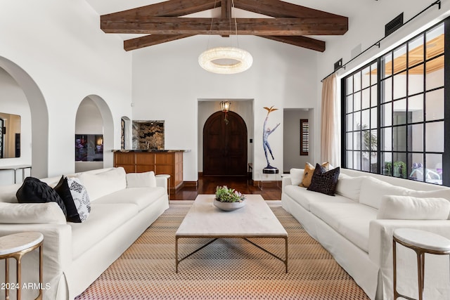 living room featuring hardwood / wood-style floors, beam ceiling, and a high ceiling