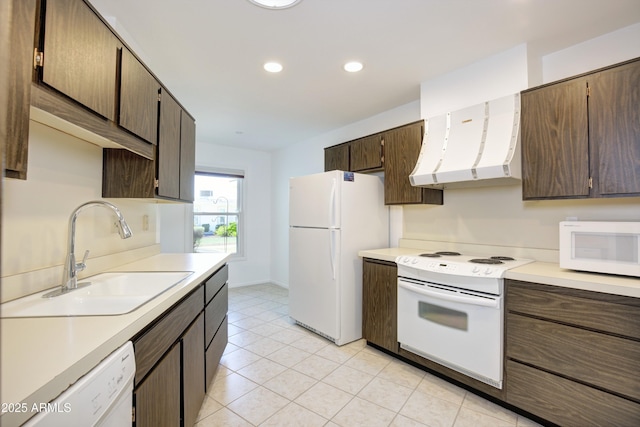 kitchen featuring white appliances, extractor fan, dark brown cabinetry, and sink