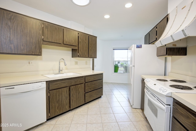 kitchen with white appliances, exhaust hood, light tile patterned floors, dark brown cabinets, and sink