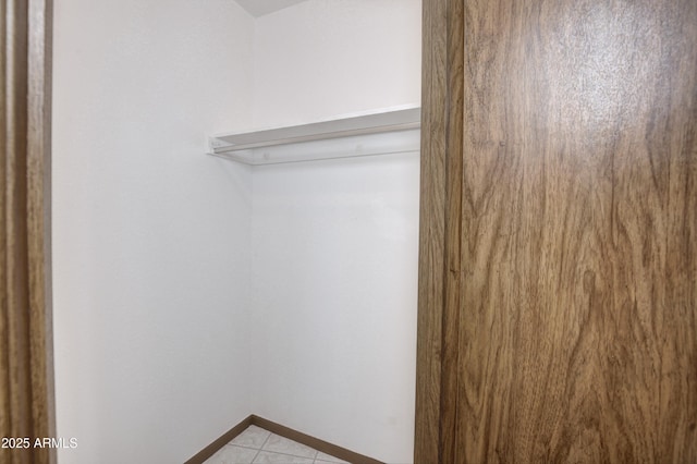 spacious closet with light tile patterned floors