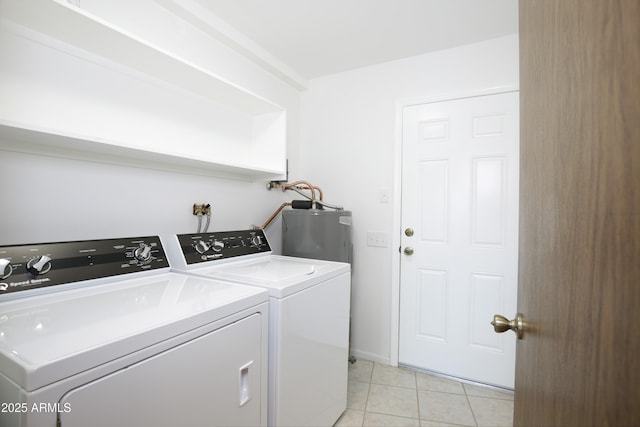 laundry room featuring washing machine and dryer, electric water heater, and light tile patterned floors