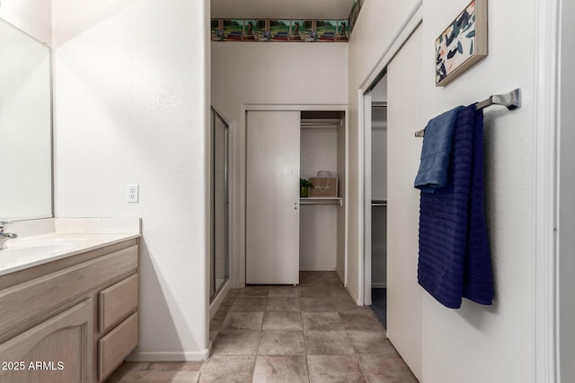 23756 S Vacation Way, Sun Lakes, AZ 85248 - bathroom featuring vanity, baseboards, a spacious closet, and a stall shower