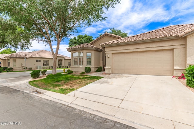 23756 S Vacation Way, Sun Lakes, AZ 85248 - mediterranean / spanish-style home with an attached garage, concrete driveway, stucco siding, and a tiled roof