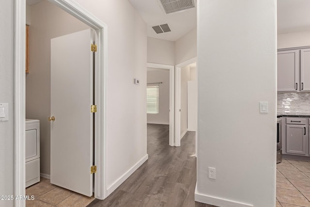 hall with light hardwood / wood-style floors and washer / dryer