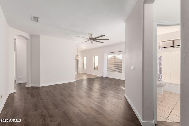 unfurnished living room featuring ceiling fan and dark hardwood / wood-style flooring