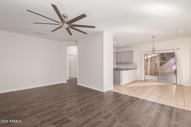 unfurnished living room with ceiling fan and light hardwood / wood-style flooring