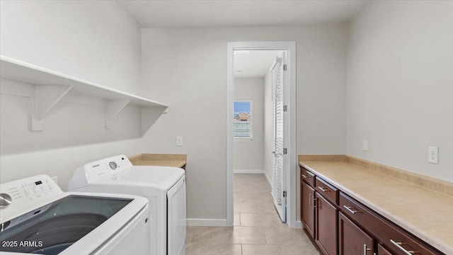 laundry area featuring separate washer and dryer, light tile patterned floors, and cabinet space
