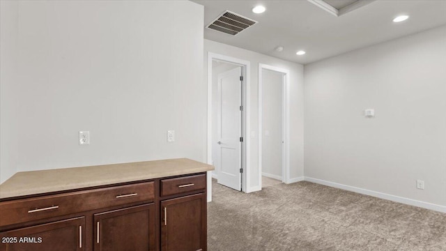 carpeted empty room with baseboards, visible vents, and recessed lighting