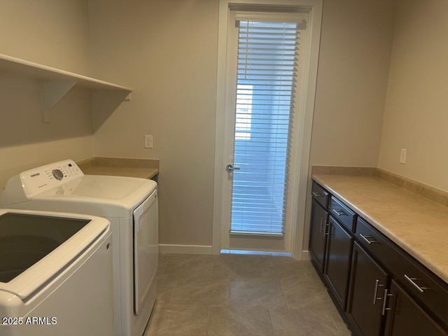 laundry room with baseboards, cabinet space, washer and clothes dryer, and light tile patterned floors